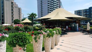 Un jardín en la azotea con plantas en macetas y mobiliario para exteriores.