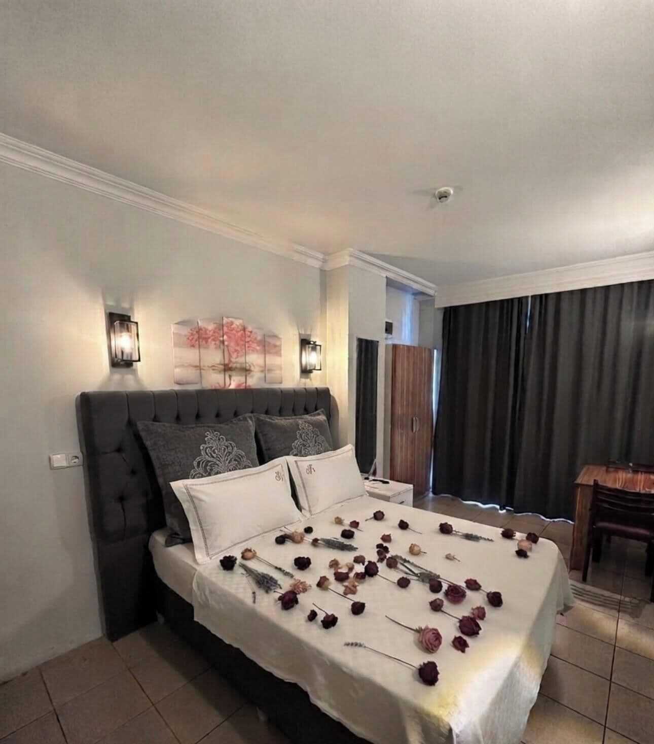 Une chambre d’hôtel avec un lit, une table de chevet, une lampe et une vue sur l’extérieur.