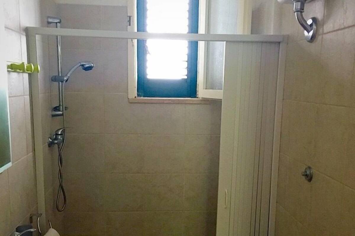 Un bany petit amb vàter, rentapel obert i plat de dutxa.
