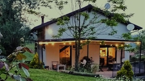 Una casa con un patio cubierto, una mesa de comedor y sillas.
