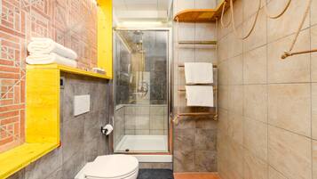 A bathroom with a toilet, a glass-enclosed shower, and a towel rack.
