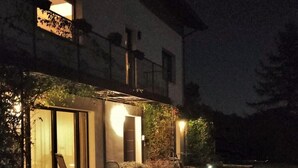 Un edificio de dos plantas con un patio cubierto, asientos exteriores y una piscina pequeña.