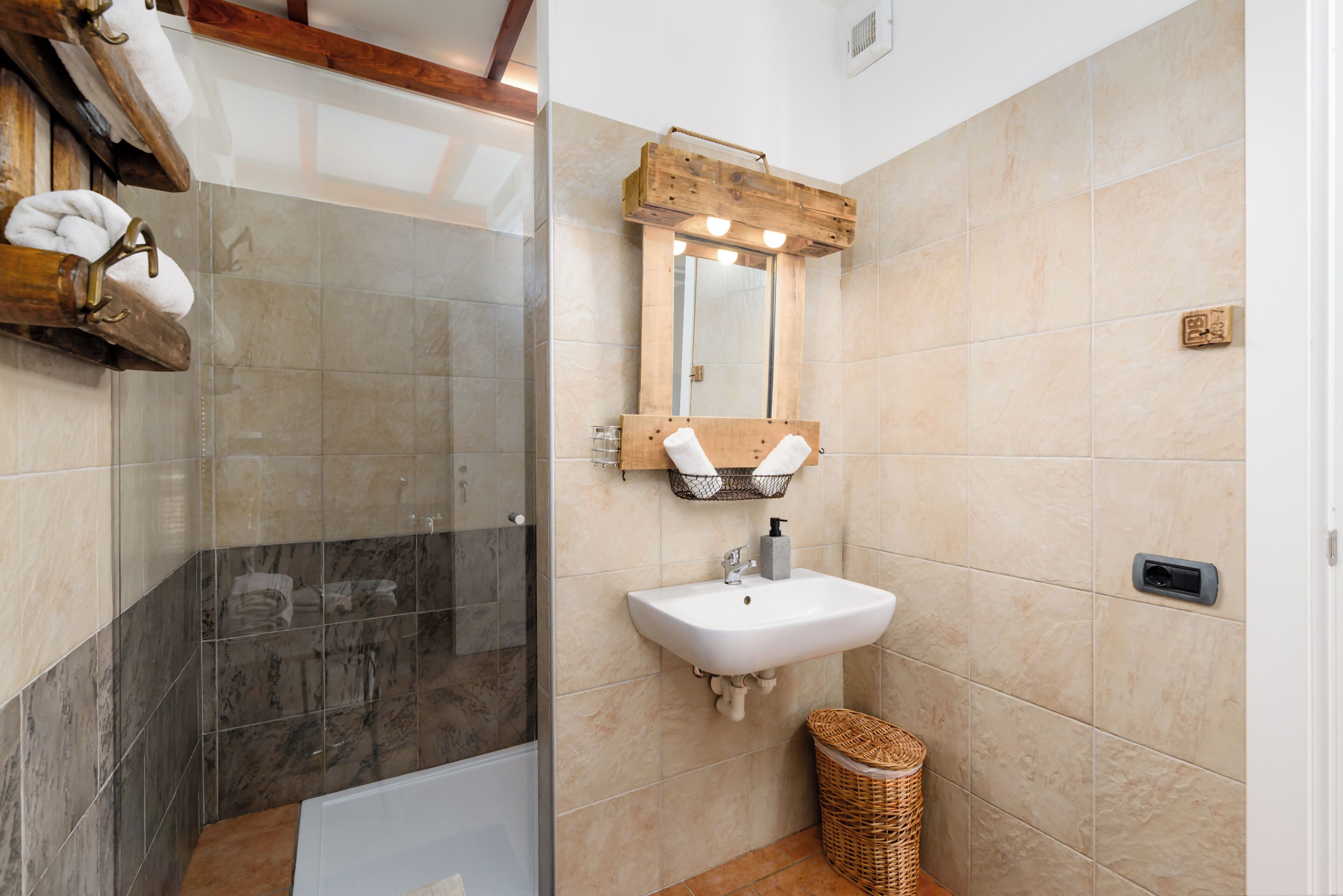 Ein Badezimmer mit Dusche, Waschbecken und Spiegel.