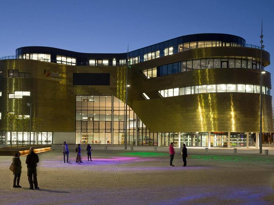 Un edificio moderno con fachada curva, ventanas amplias y techo plano.
