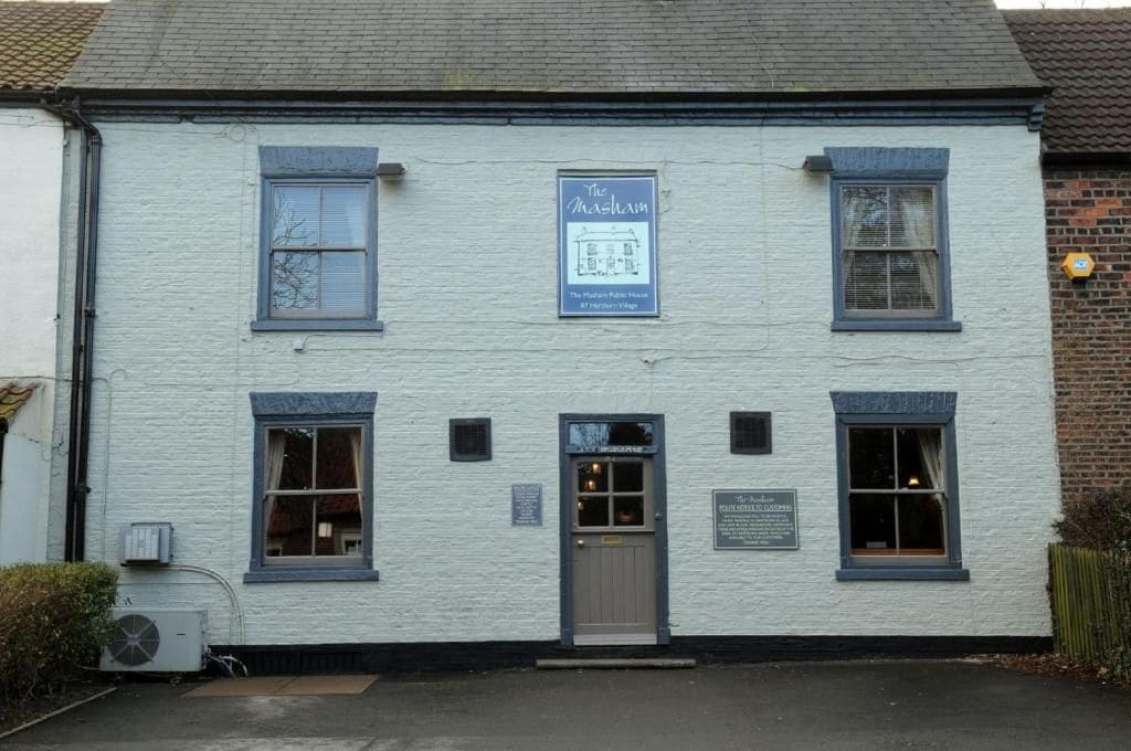 A white building with a sign reading 'The Marsham.'