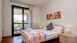 A bedroom with a bed, a nightstand, a window with a view, and a painting on the wall. - Desenzanoloft – Butterfly and Pools (Desenzano del Garda)