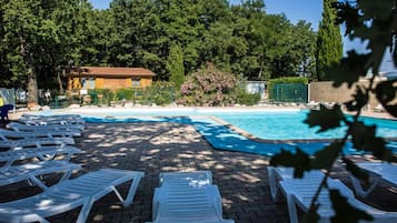 Una piscina al aire libre, tumbonas