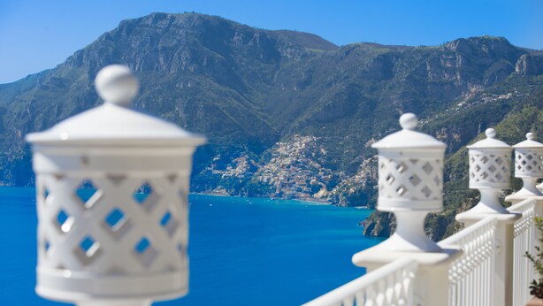 A coastal balcony with white railings and decorative lanterns, overlooking a mountainous landscape and a clear blue sea. - B&B La Barbera (Praiano)