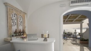 A reception area with a laptop, decorative keys, and a candle on a white counter. - B&B La Barbera (Praiano)