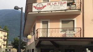 A building with a sign for 'DE LA TOUR Bar - B&B' on the second floor. - De La Tour (Tirano)