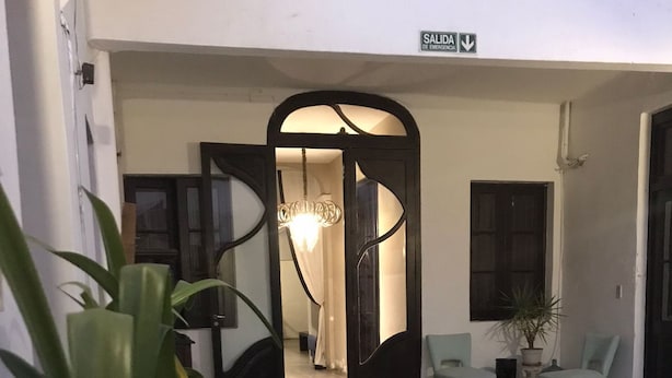 Un'area della hall con reception, zona salotto e una scala che conduce a un piano superiore.