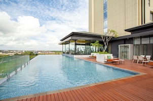 Una piscina al aire libre, sombrillas, sillones reclinables de piscina