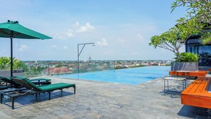 Alberca al aire libre, sombrillas en la alberca y camastros 