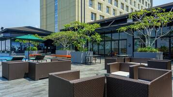 Een buitenzwembad, parasols bij het zwembad en ligstoelen