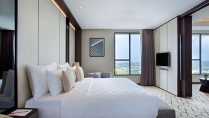 Une chambre d’hôtel moderne dotée d’un grand lit, d’une télévision à écran plat et offrant une vue sur la ville.