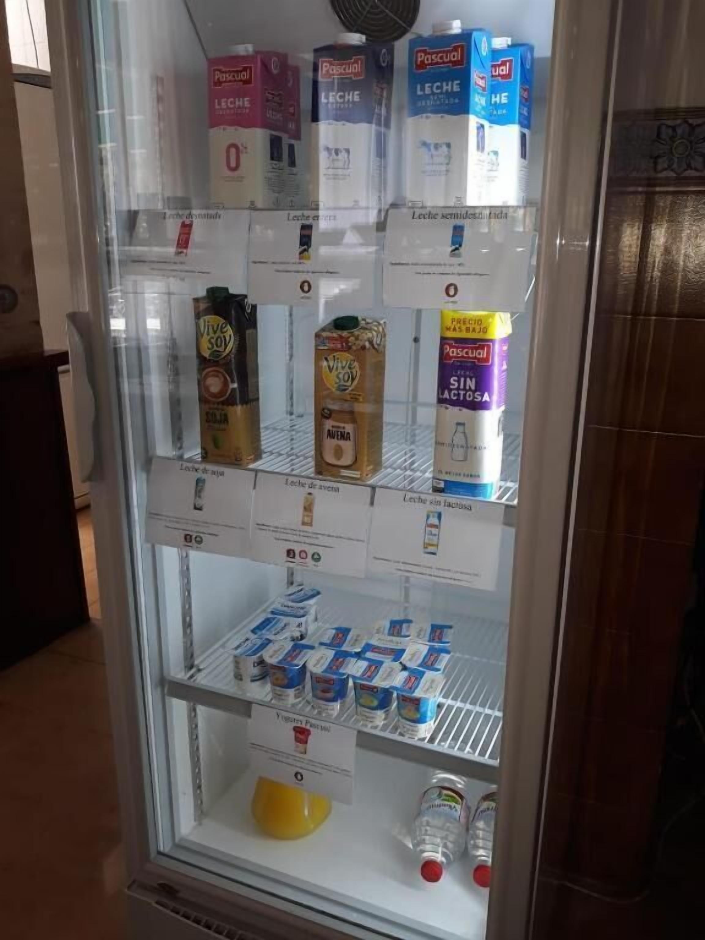 Vitrina refrigerada con diversos productos lácteos, como leche, queso y yogur.