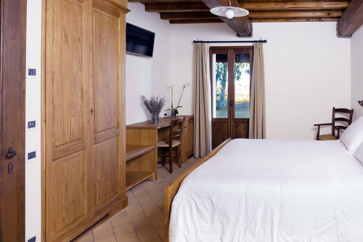 Un dormitorio con una cama de madera, un escritorio y un armario.