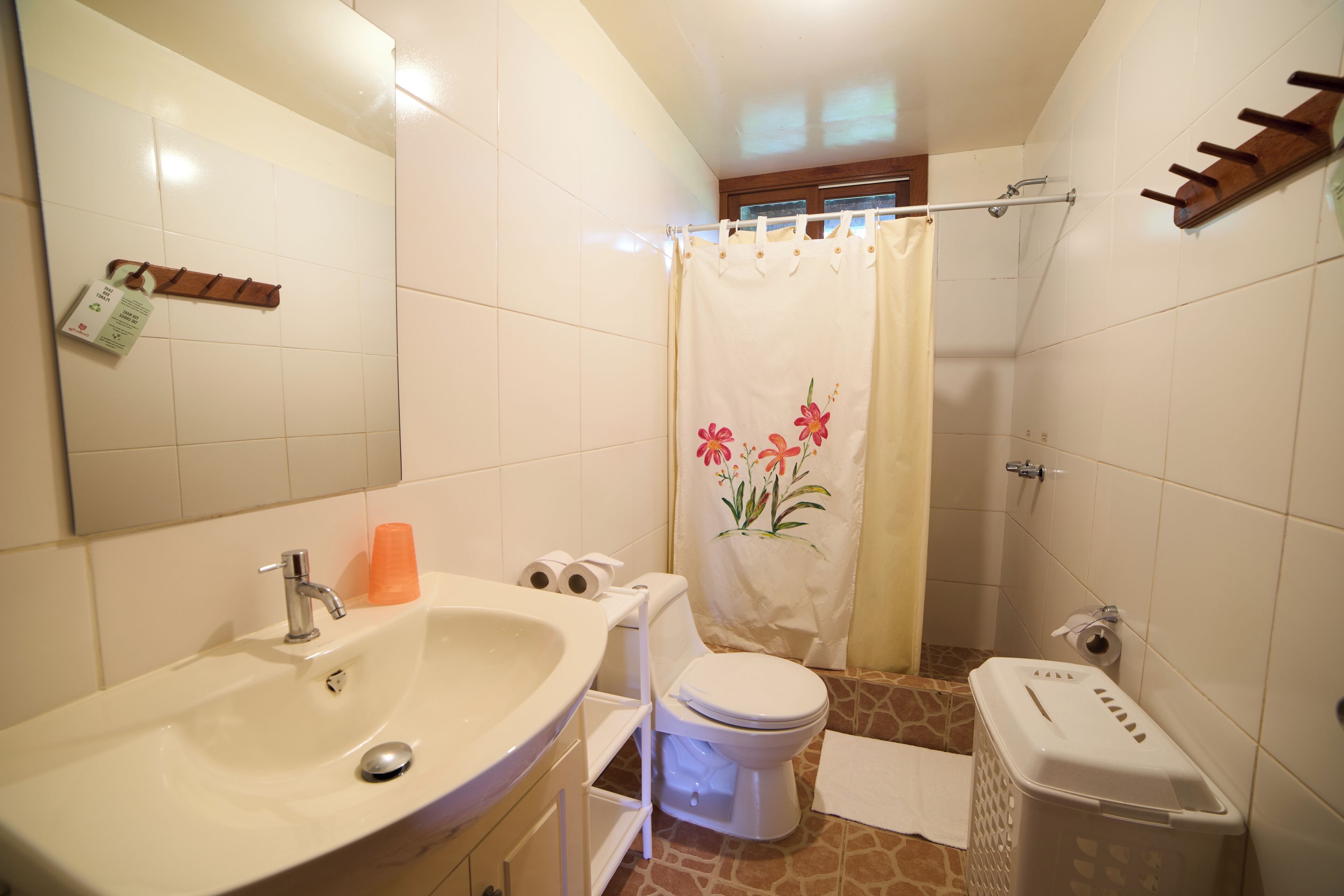 Une salle de bain équipée d’un lavabo, de toilettes et d’un rideau de douche.