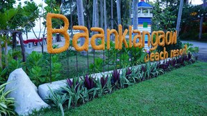 Señal para el Baankatoon Beach Resort, con un entorno de jardín tropical.