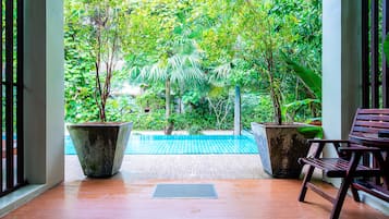 Una piscina al aire libre, sillones reclinables de piscina