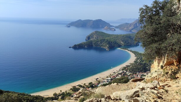 A coastal landscape with rocky terrain and a beach.