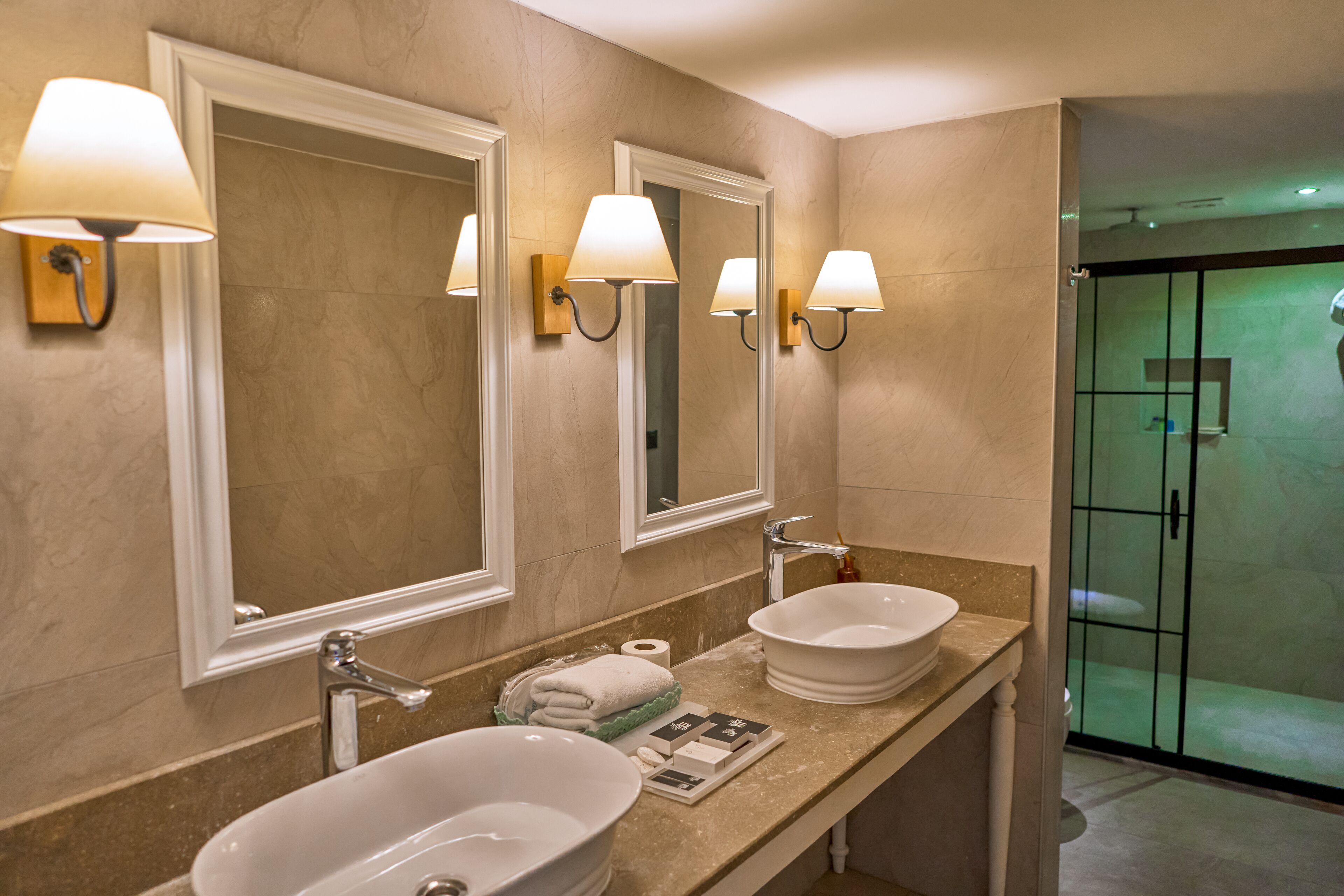 Ein Badezimmer mit zwei Waschbecken, Spiegeln und Wandleuchten.