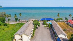 Ein Hotel an der Küste mit großem Parkplatz, Schwimmbad und Meerblick.