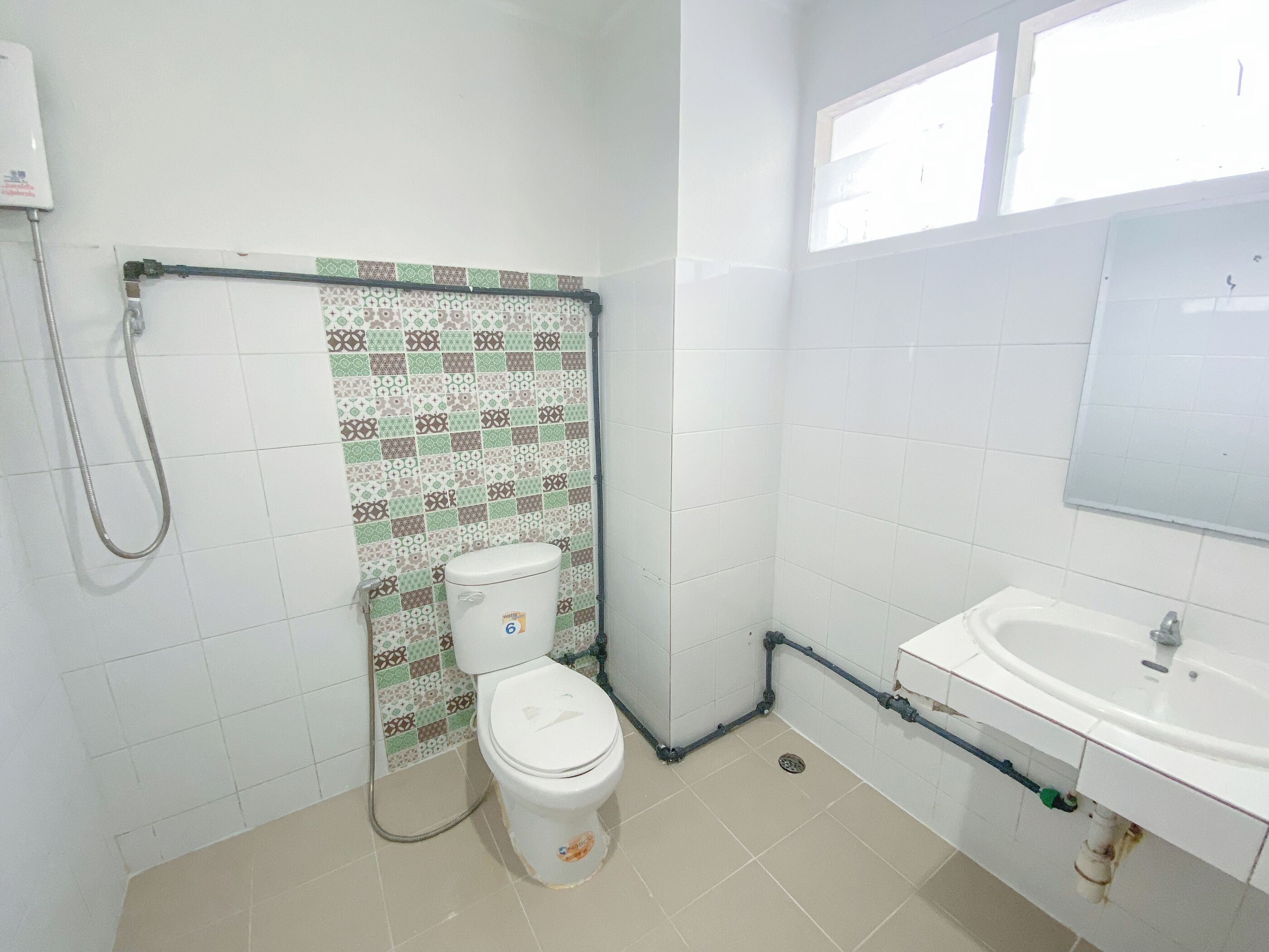 A small bathroom with a toilet, a shower, and a sink.
