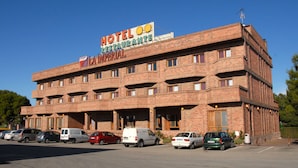 Un hotel de varios pisos con un cartel llamativo que dice "HOTEL RESTAURANT LA IMPERIAL".