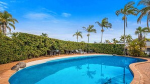A swimming pool with lounge chairs and palm trees. - Comfort Inn North Brisbane (Carseldine)