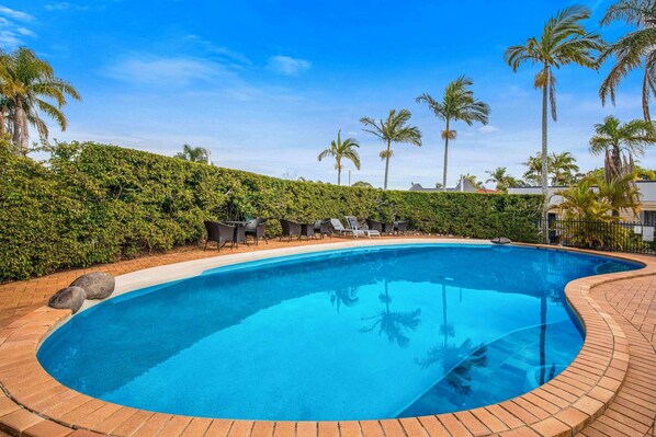 Una piscina al aire libre, tumbonas