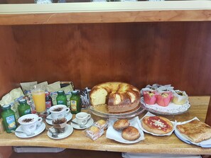 Un buffet de petit-déjeuner proposant une variété d’aliments, de boissons et un gâteau.