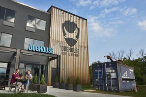 A building with a wooden facade and a large logo. - DogHouse Columbus (Canal Winchester)