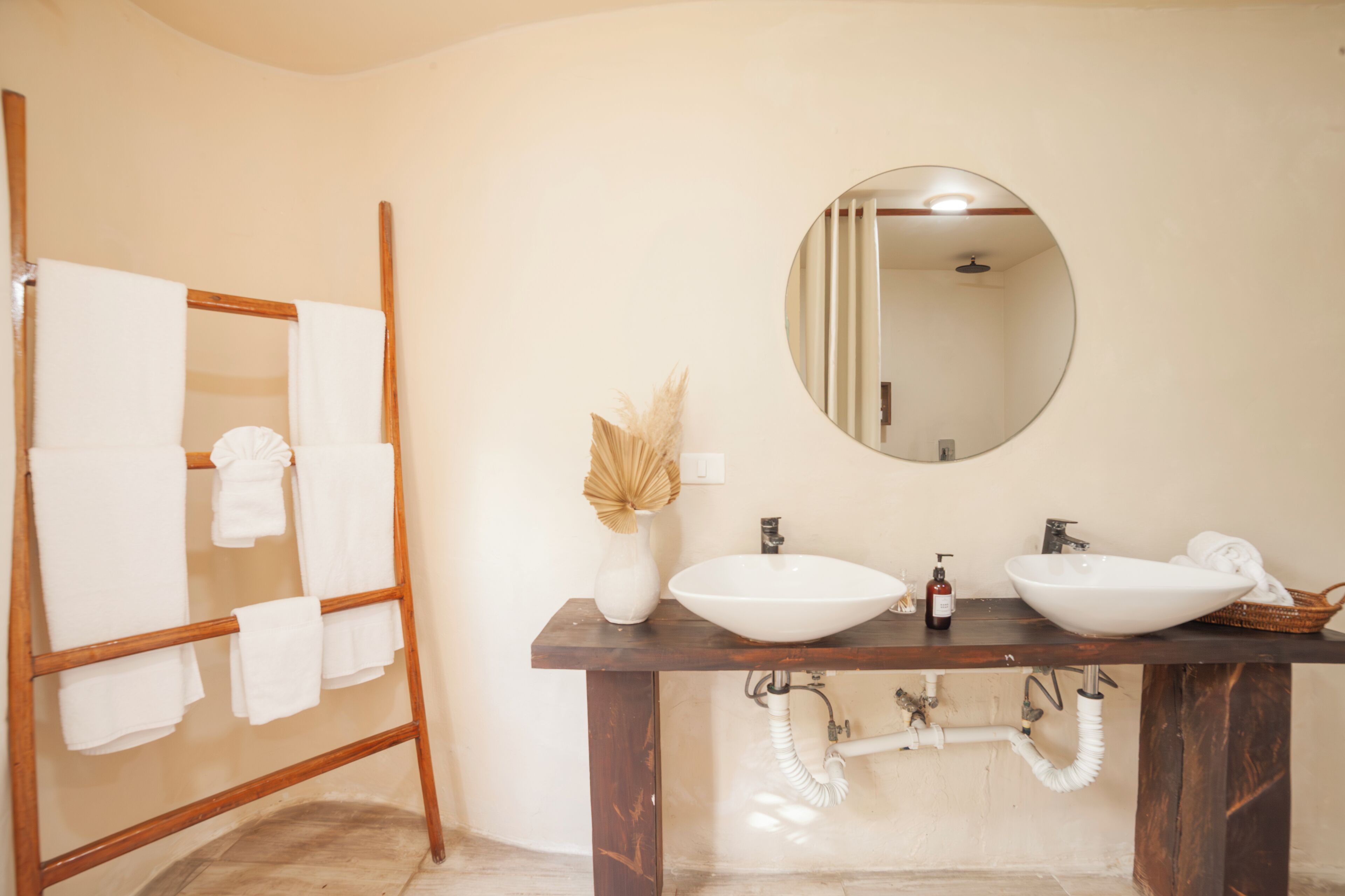 A bathroom with two sinks, a mirror, and a towel rack.