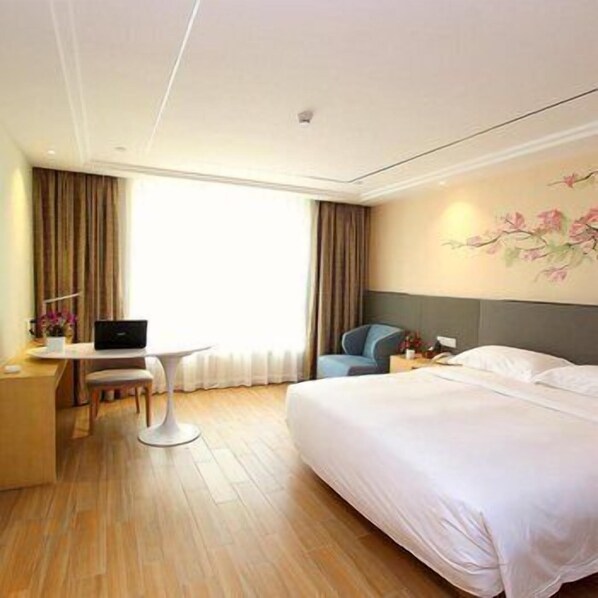 A hotel room with a large bed, a desk with a laptop, a chair, and a window with curtains. - U-hotel (Shenzhen)