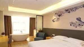 A modern hotel room with a large bed, a bathtub, and a seating area. - U-hotel (Shenzhen)