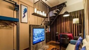 Una sala de estar moderna con una televisión de pantalla plana, una escalera y un comedor.