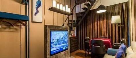 Un salon moderne doté d’un téléviseur à écran plat, d’un escalier et d’un coin repas.