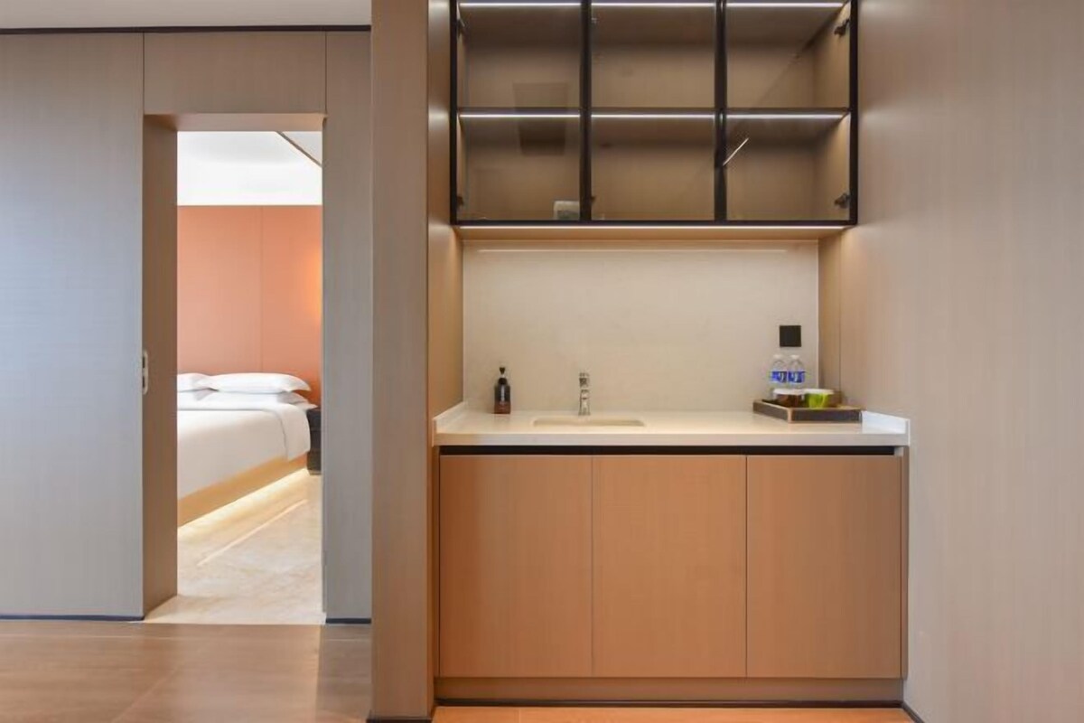 A modern bathroom with a sink, mirror, and storage cabinets.