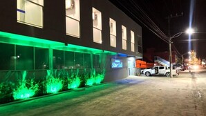 Un edificio con fachada moderna, amplios ventanales y un letrero de neón.