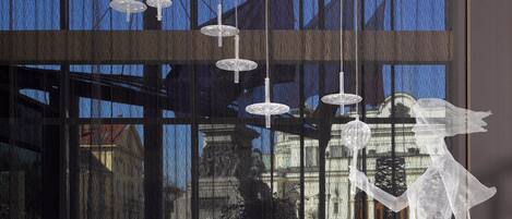 Un interior modern amb llums penjants i una paret de vidre reflectant.