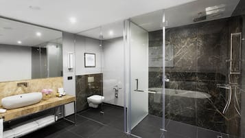 Een moderne badkamer met een glazen douchecabine, een marmeren wastafel en een toilet.