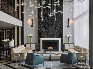 A modern living room with a fireplace, two sofas, a coffee table, and hanging pendant lights. - InterContinental Sofia by IHG (Sofia)