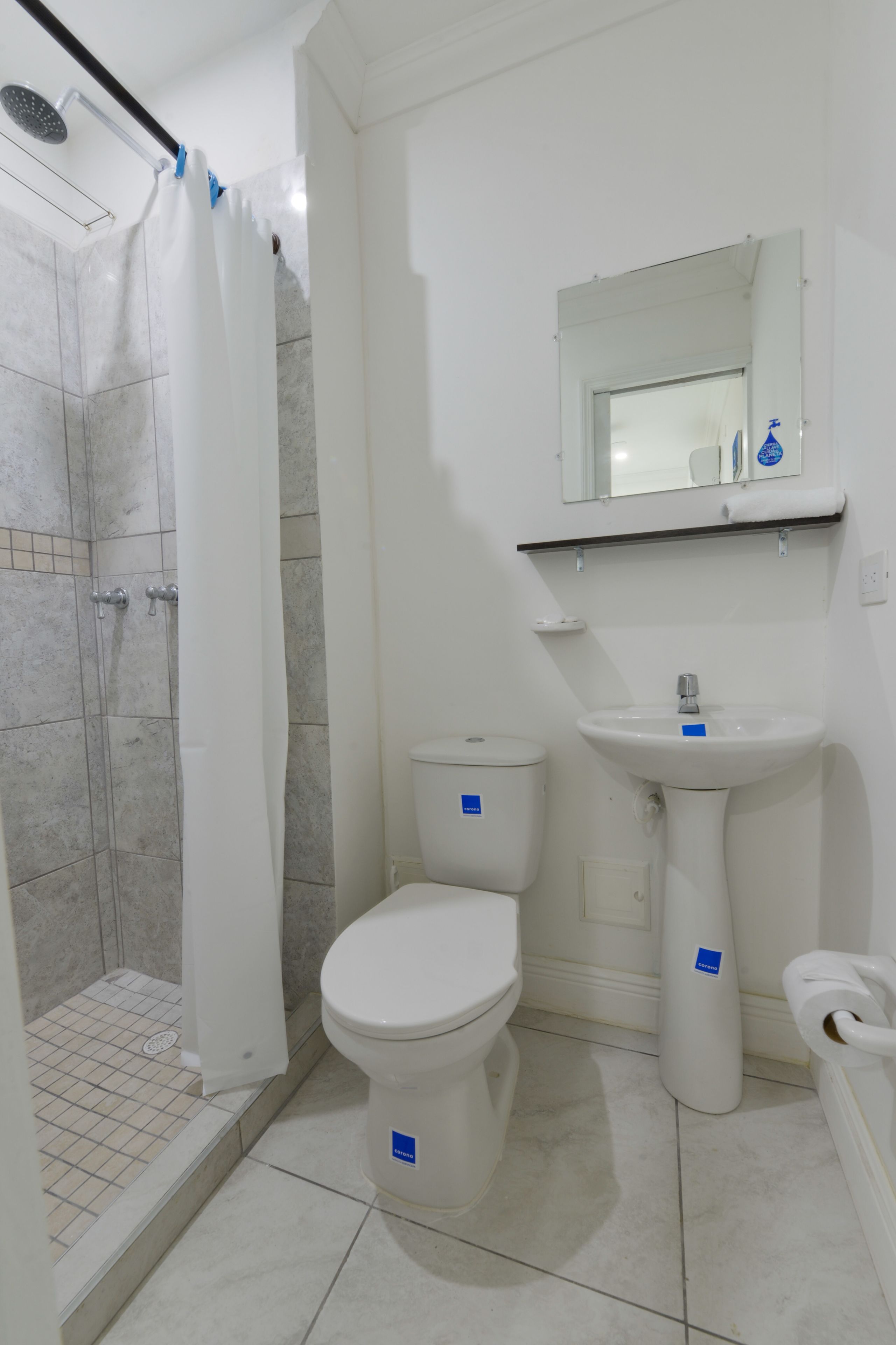 A bathroom with a shower, toilet, and sink.