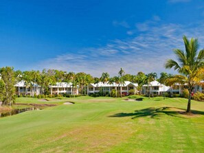 A golf course with a clubhouse and several white-roofed buildings.