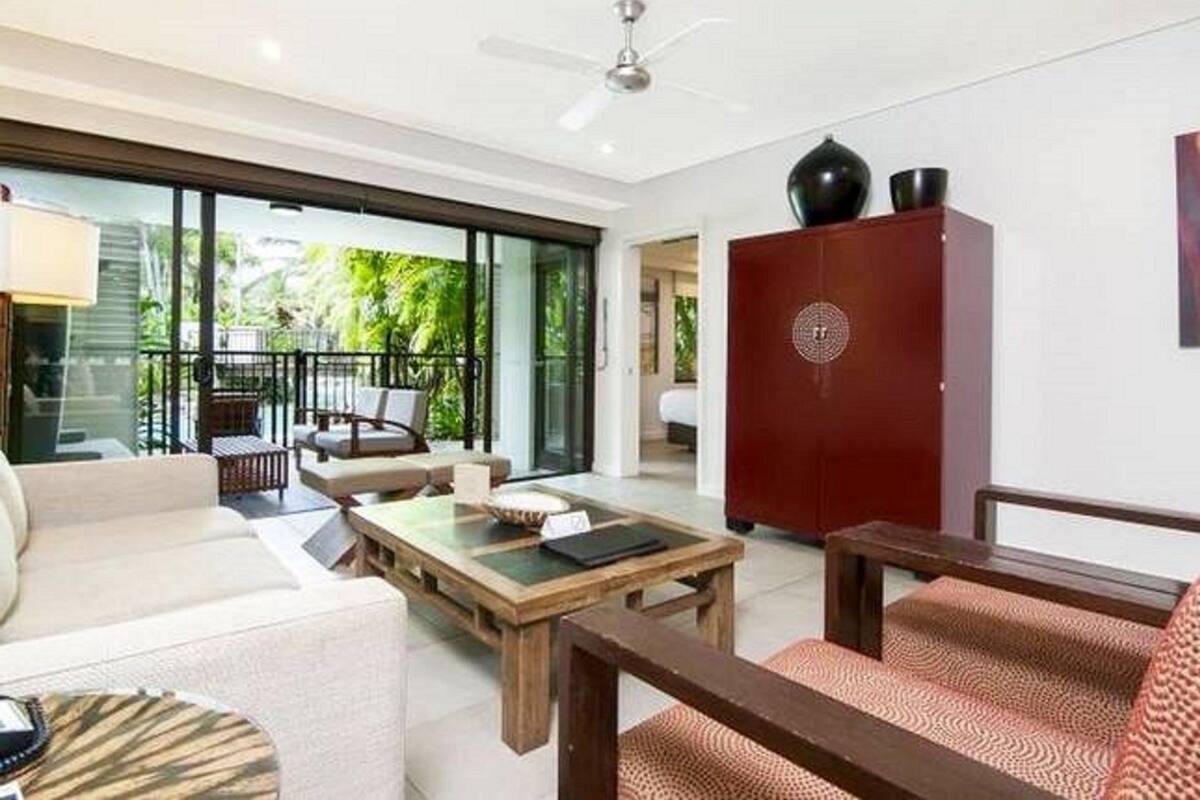 A modern living room with a sofa, coffee table, and a red cabinet.