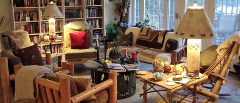 A cozy living room with a bookshelf, a sofa, a coffee table, and a chair.