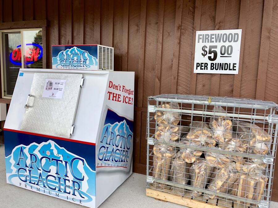 Un congelador con un cartel que anuncia hielo premium Arctic Glacier a $5.00 por paquete.