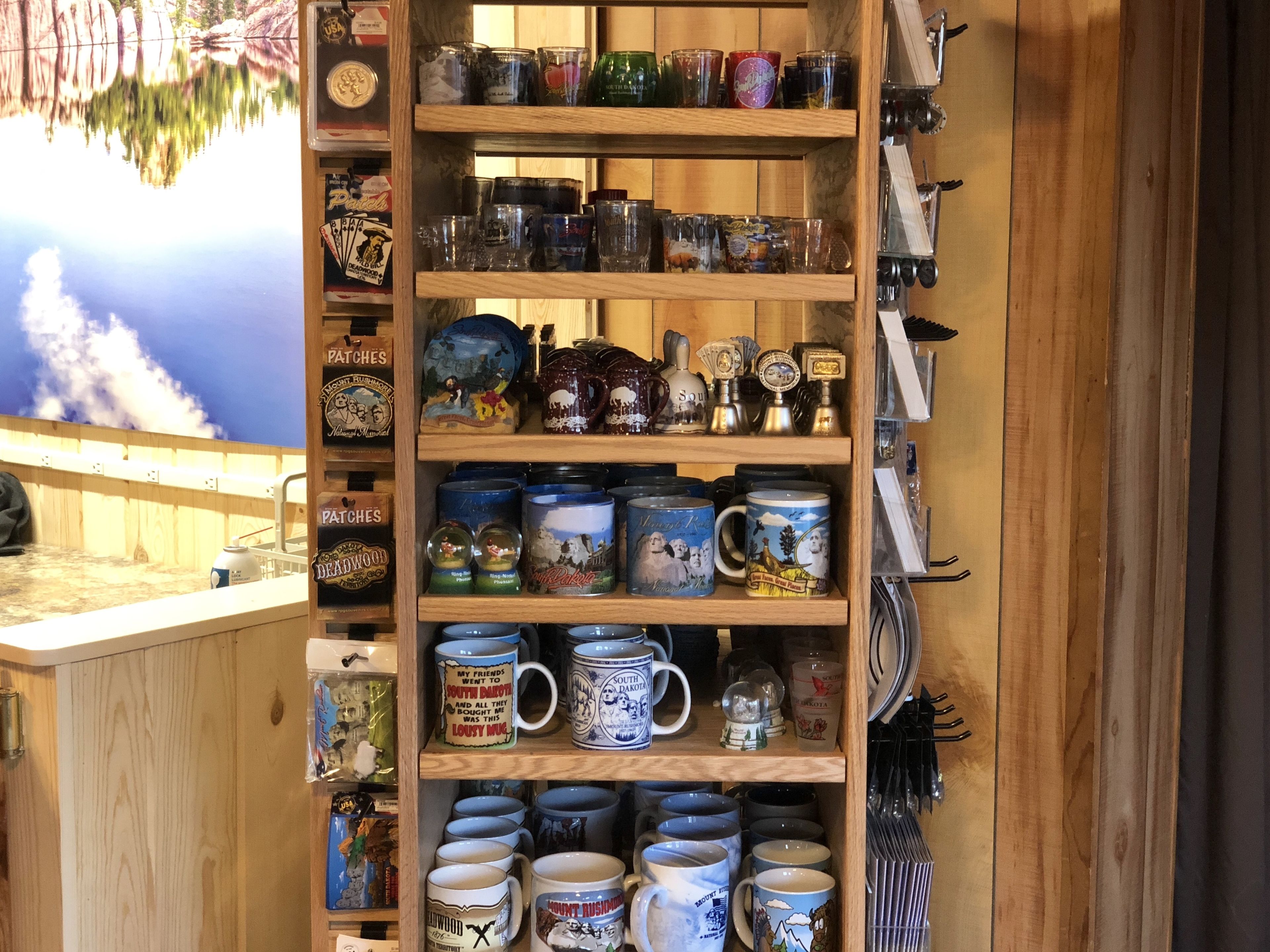 A wooden shelf with various mugs and decorative items.