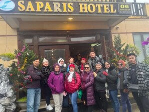 A group of people outside a hotel with a sign that reads 'Saparis Hotel.' - Sapa Sweet Time Hotel (Sa Pa)